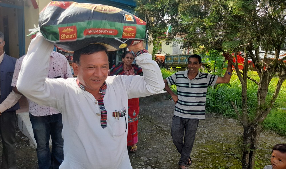 चामलको थैलो बोकेर तनहुँ व्यास १० का वडाध्यक्ष सापकोटा अपाङ तथा विपन्नको दैलोमा 