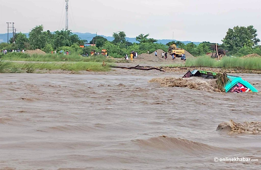चितवन माडी स्थित घाँघर खोला तर्दै गर्दा बाढीमा डुब्यो बस, यात्रु सकुशल